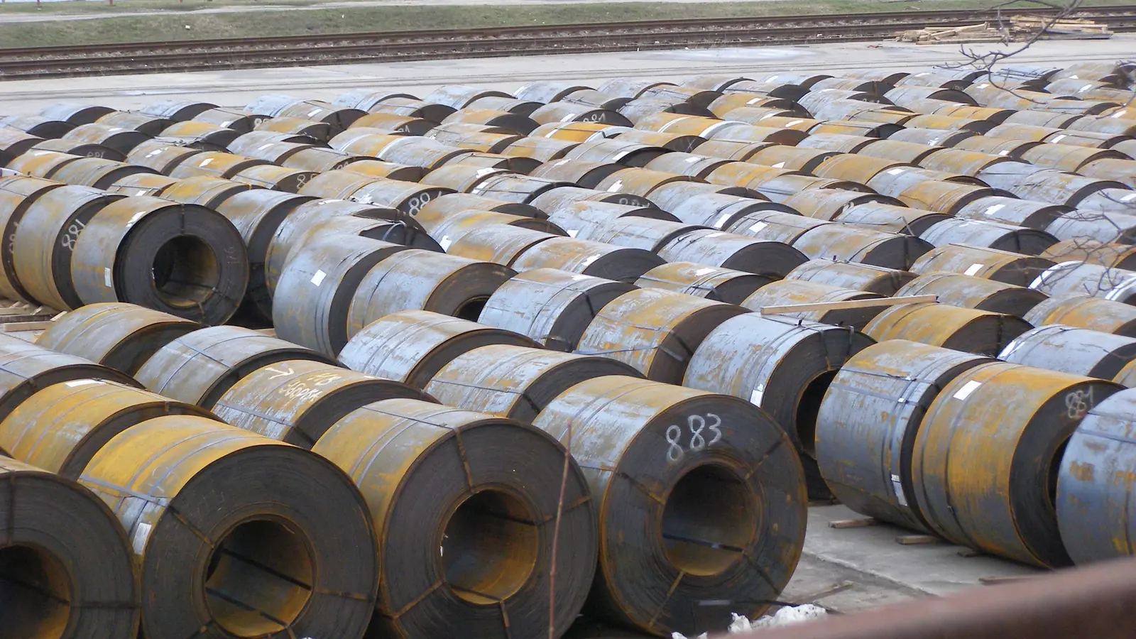 Illustrative image of hot rolled steel coils in an open stockyard (not Jayesh Steel stock)