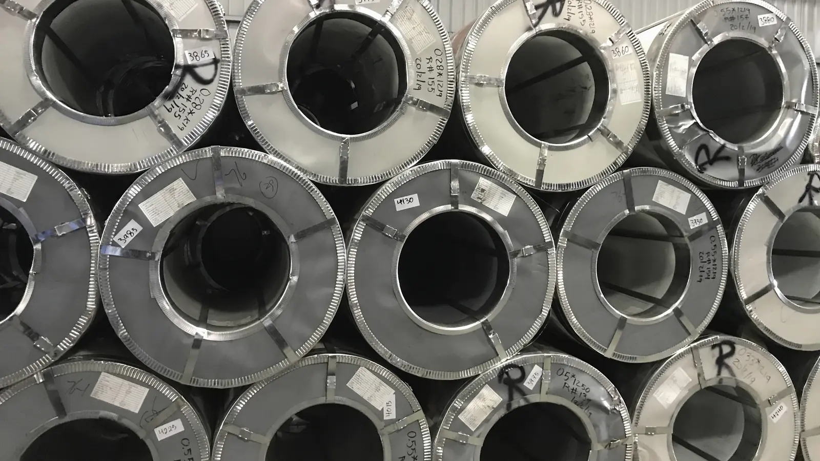 Illustrative image of the ends of stacked steel coils in a warehouse