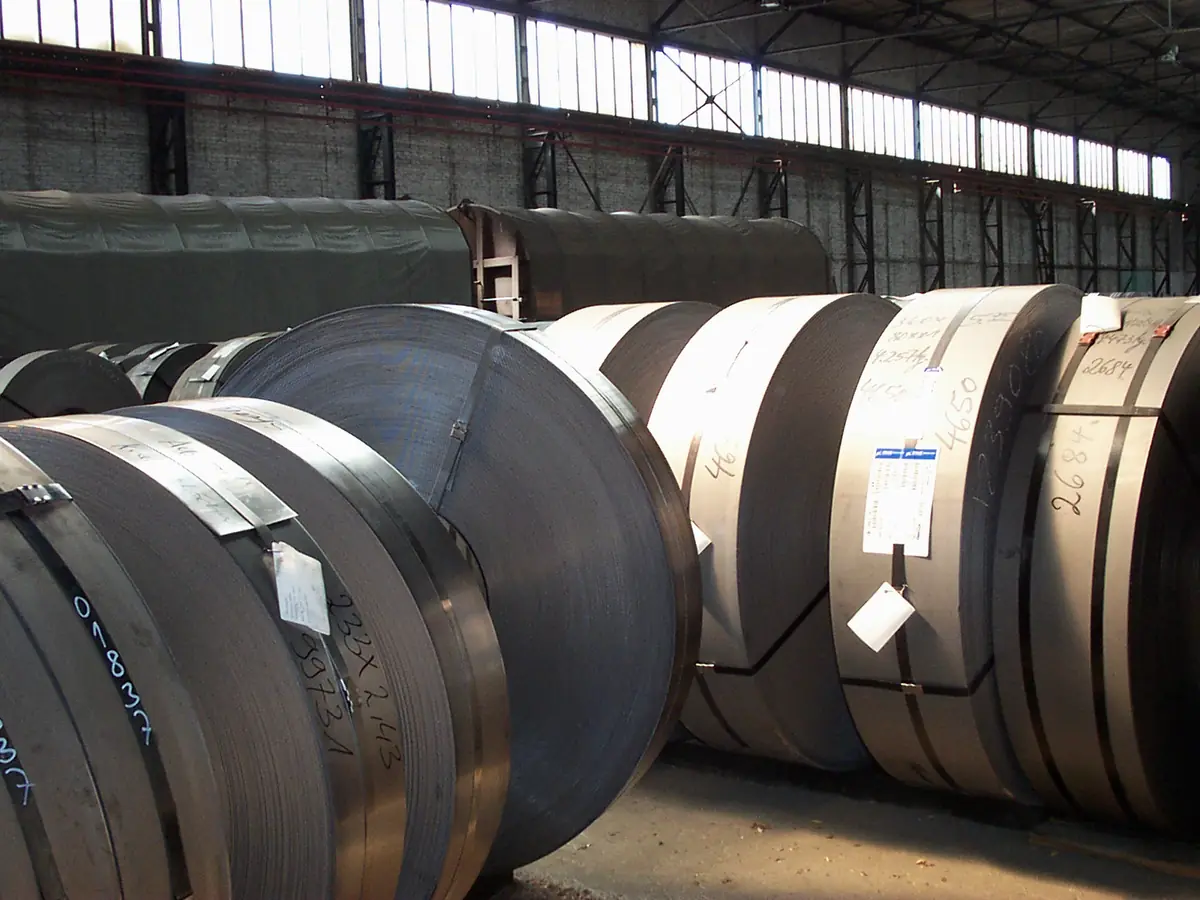 Illustrative image of hot rolled steel coils in a warehouse hall (not Jayesh Steel stock)