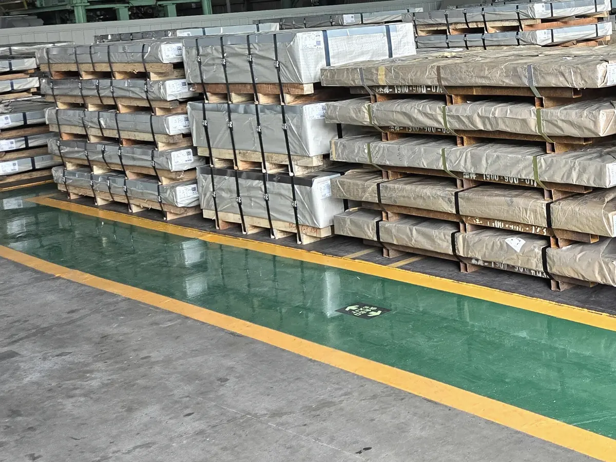 Illustrative image of rows of steel plate packs on timber bearers (not Jayesh Steel stock)